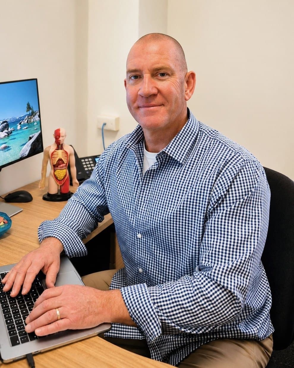 Adrian Hallam, diagnostic naturopath, at his desk in the consulting room